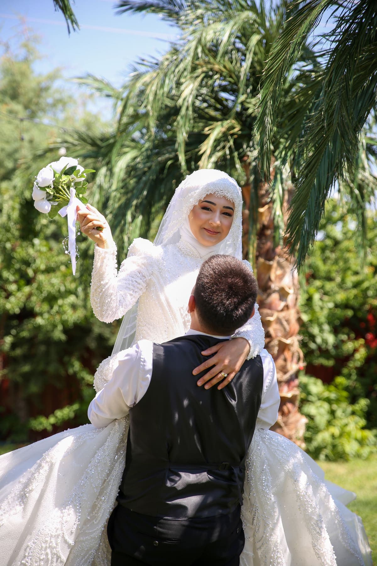 Gelini kaldıran damat — bahçe düğün karesi